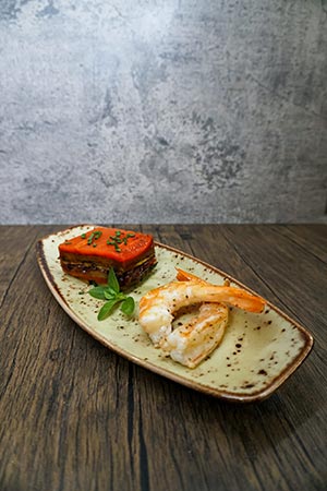 Gourmet dish of seared shrimp and vegetable terrine, artistically plated by a private chef in Tenerife.